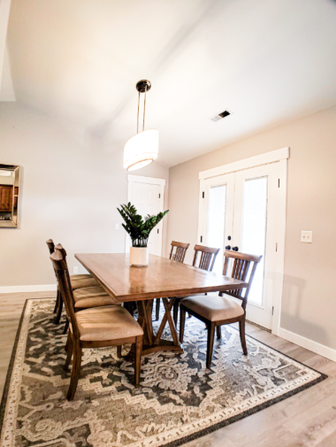 Bright dining room with farmhouse table, upholstered chairs and French doors