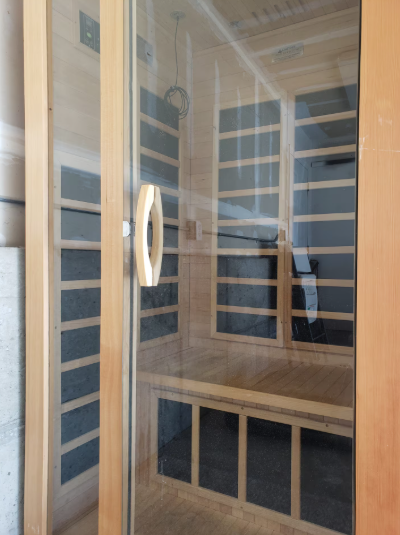Private infrared sauna with cedar wood benches and glass door