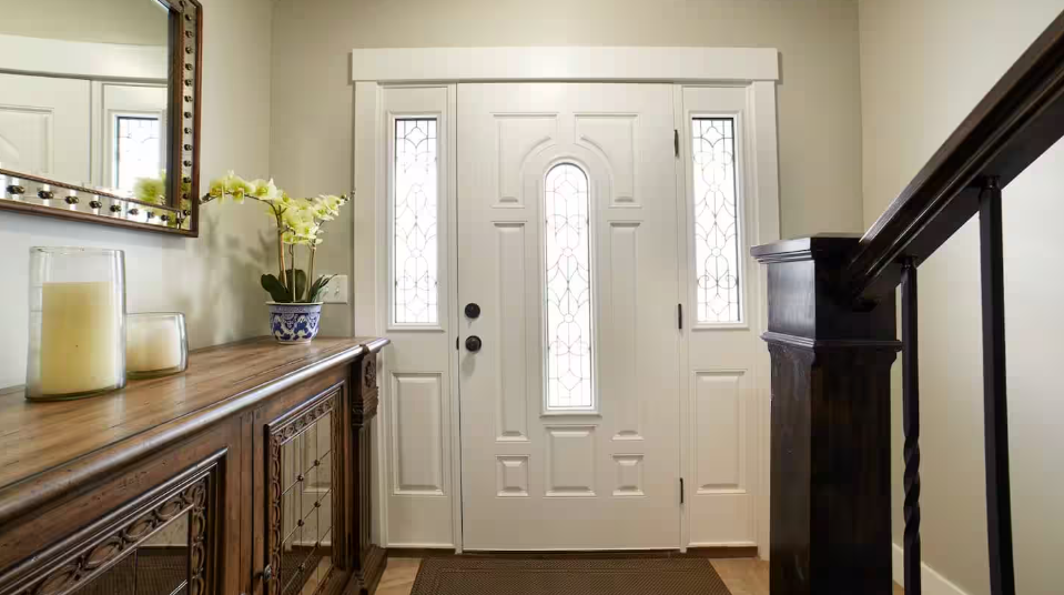 Elegant entryway with dark wood furnishings and arched front door