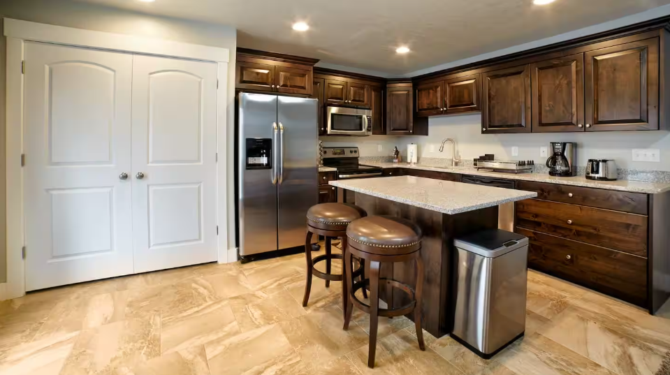 Fully equipped kitchen with dark wood cabinets, granite island and stainless appliances