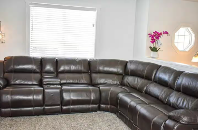 Spacious living room with dark leather sectional sofa